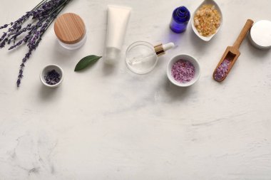 Lavanta çiçekli doğal kozmetik ürünleri ve beyaz grunge arka planda deniz tuzu.