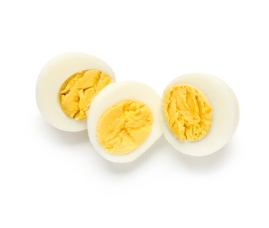 Beyaz arka planda izole edilmiş lezzetli haşlanmış yumurta parçaları.