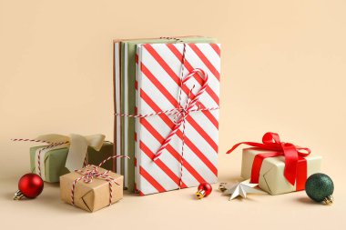 Kitaplar, Noel baloları ve bej arka planda hediye kutuları