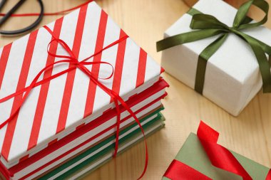 Kitap yığını ve Noel hediyesi kutuları ahşap arka planda, yakın plan