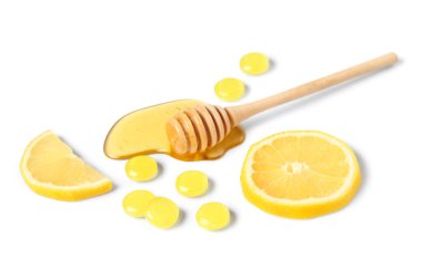 Beyaz arka planda bal ve limon dilimleri ile öksürük pastili
