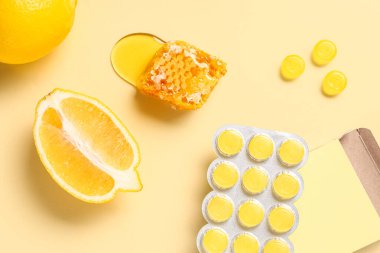 Limonlu öksürük damlaları ve sarı arka planda bal peteği.