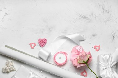 Hediye kutusu, ambalaj kağıdı ve beyaz masada gül. Sevgililer Günü kutlaması