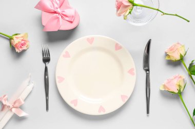 Gül çiçekleri, mumlar ve gri arka planda hediye kutusuyla Sevgililer Günü için masa ayarı