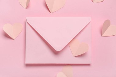Aşk mektubu ve pembe arka planda kağıt kalpler olan kompozisyon, yakın plan. Sevgililer Günü kutlaması