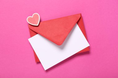 Kırmızı zarflı kompozisyon ve pembe arka planda boş kart. Sevgililer Günü kutlaması