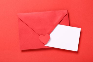 Zarflı kompozisyon ve kırmızı arka planda boş kart. Sevgililer Günü kutlaması