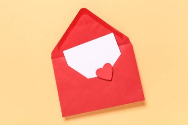 Kırmızı zarflı kompozisyon, boş kart ve turuncu arka planda kağıt kalp. Sevgililer Günü kutlaması