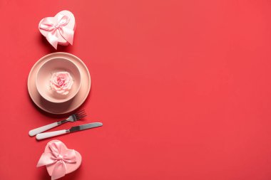 Sevgililer Günü için güzel bir masa. Kırmızı arka planda gül çiçeği ve hediye kutuları var.