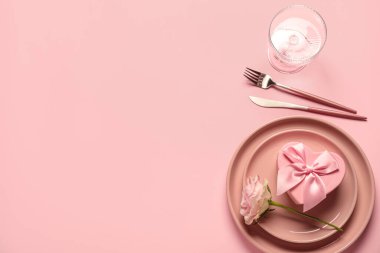 Gül çiçeği ve pembe arka planda hediye kutusuyla Sevgililer Günü için güzel bir masa.