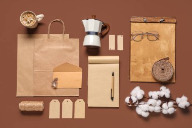 Pamuk çiçekli kompozisyon, gayzer kahve makinesi, kahverengi arka planda defter ve teslimat kağıdı.