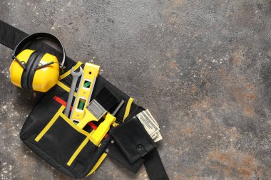 Cüzdanında para ve inşaatçının alet çantası var.