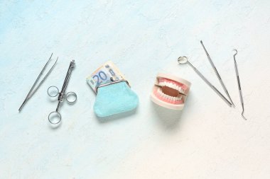 Paralı cüzdan, çene modeli ve hafif grunge arkaplan üzerinde dişçi araçları