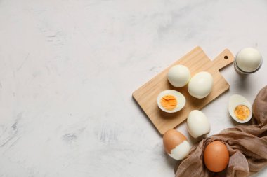 Hafif arka planda haşlanmış yumurta ve ahşap tahta.
