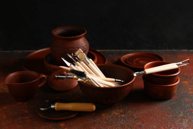 Kahverengi grunge masasında bir takım heykeltraş araçları ile kase