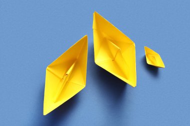 Mavi arka planda sarı kağıt tekneler