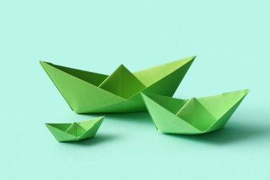 Turkuaz arka planda yeşil kağıt tekneler