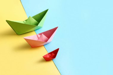 Renkli arka planda farklı kağıt tekneler