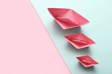 Renkli arka planda pembe kağıt tekneler