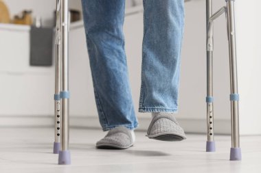 Mutfakta yürüyen yaşlı adamın bacakları.