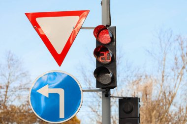 Şehirdeki zamanlayıcı ve yol işaretli kırmızı trafik ışıklarının görüntüsü