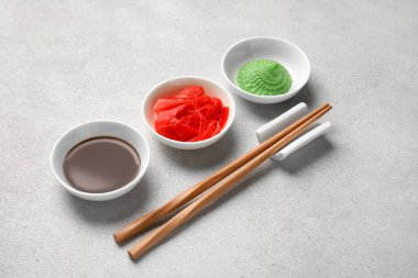 Beyaz arka planda wasabi, soya sosu ve turşulu zencefil, yakın plan.