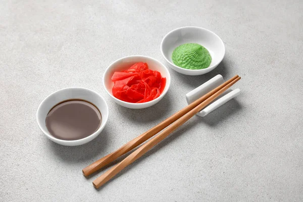 Beyaz arka planda wasabi, soya sosu ve turşulu zencefil, yakın plan.
