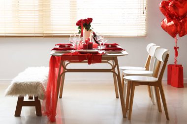 Sevgililer Günü için yemek masası ve balonlarla dolu bir oda.