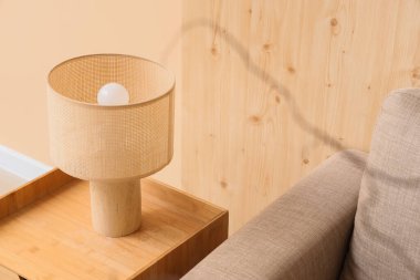 Oturma odasındaki ahşap masada şık bir lamba.