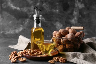 Şişeli lezzetli cevizler ve gri grunge arka planda yağlı bir tekne.