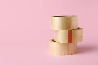 Pembe arka planda yapışkan bant ruloları