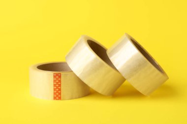 Sarı arkaplanda yapışkan bant ruloları
