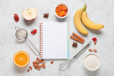 Beyaz grunge arka planında pişirme için boş tarif kitabı, kap kacak ve ürünler içeren kompozisyon
