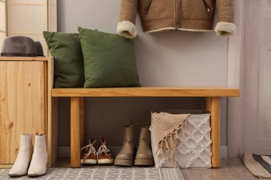 Koridordaki tahta bankta kışlık botlar.