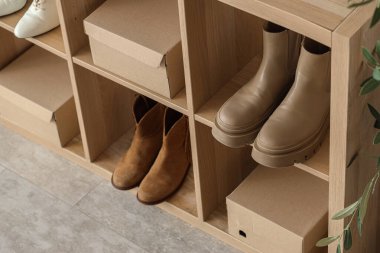 Butikte kışlık botları ve ayakkabı kutuları olan raf ünitesi.