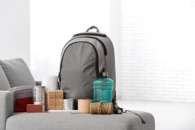 Odadaki kanepede acil durum çantası ve gerekli şeyler.