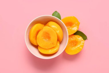 Pembe arka planda tatlı şeftali konservesi