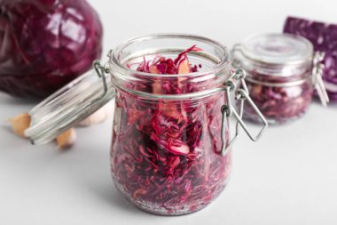 Gri arka planda sarımsaklı lezzetli kırmızı lahana turşusu.