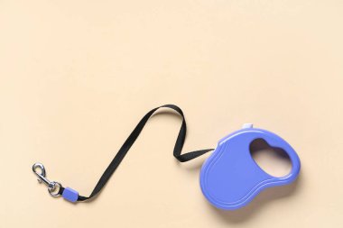 Retractable dog leash on beige background