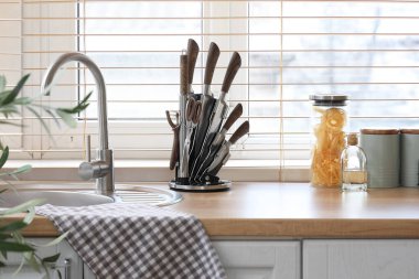Mutfak penceresinin yanındaki tezgahta bıçak seti.