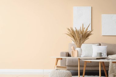 Kanepesi, masası ve tablosu olan şık bir oturma odası.