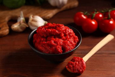 Tahta arka planda sarımsak ve sebzeli domates ezmesi, yakın plan.