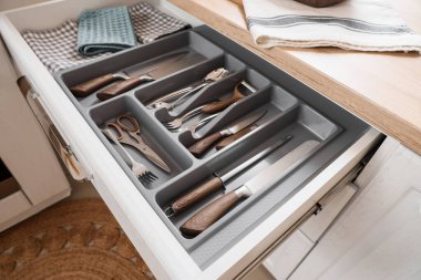 Mutfakta çatal bıçak takımı olan bir çekmece aç.