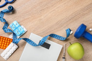 Ölçekli kompozisyon, mezura ve tahta arka planda haplar