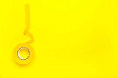 Renk arkaplanındaki sarı yalıtkan bant rulosu