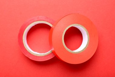 Renk arkaplanında kırmızı izolasyon bandı ruloları, yakın plan