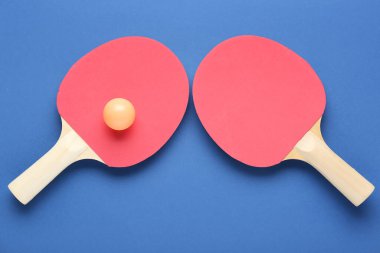 ping pong raketleri ve top mavi arkaplanda