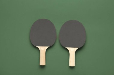 Yeşil arka planda siyah ping pong raketleri