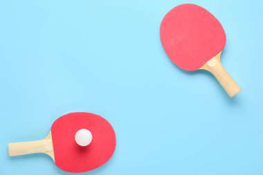 ping pong raketleri ve top mavi arkaplanda