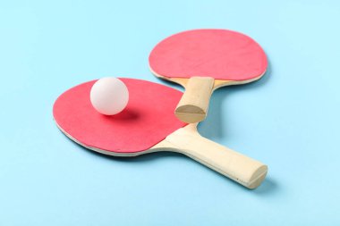 ping pong raketleri ve top mavi arkaplanda